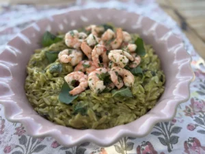 Baked courgette orzo topped with garlic and chilli prawns and fresh basil.